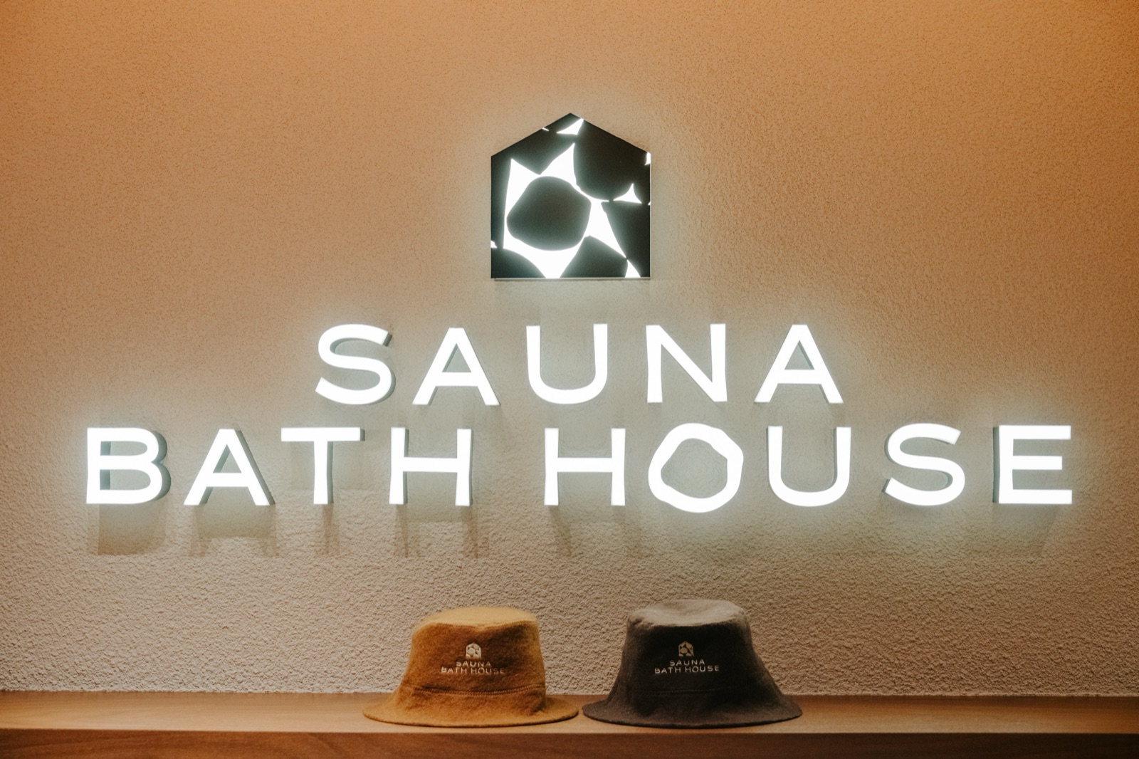 Sauna Bath House hats below the lit sign